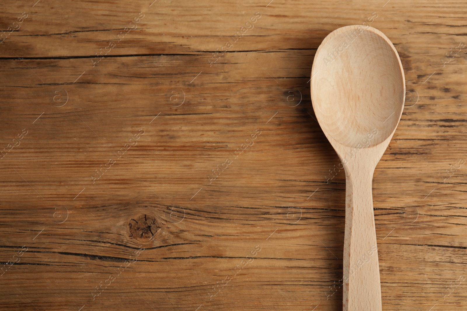 Photo of Handmade wooden spoon on rustic table, top view. Space for text