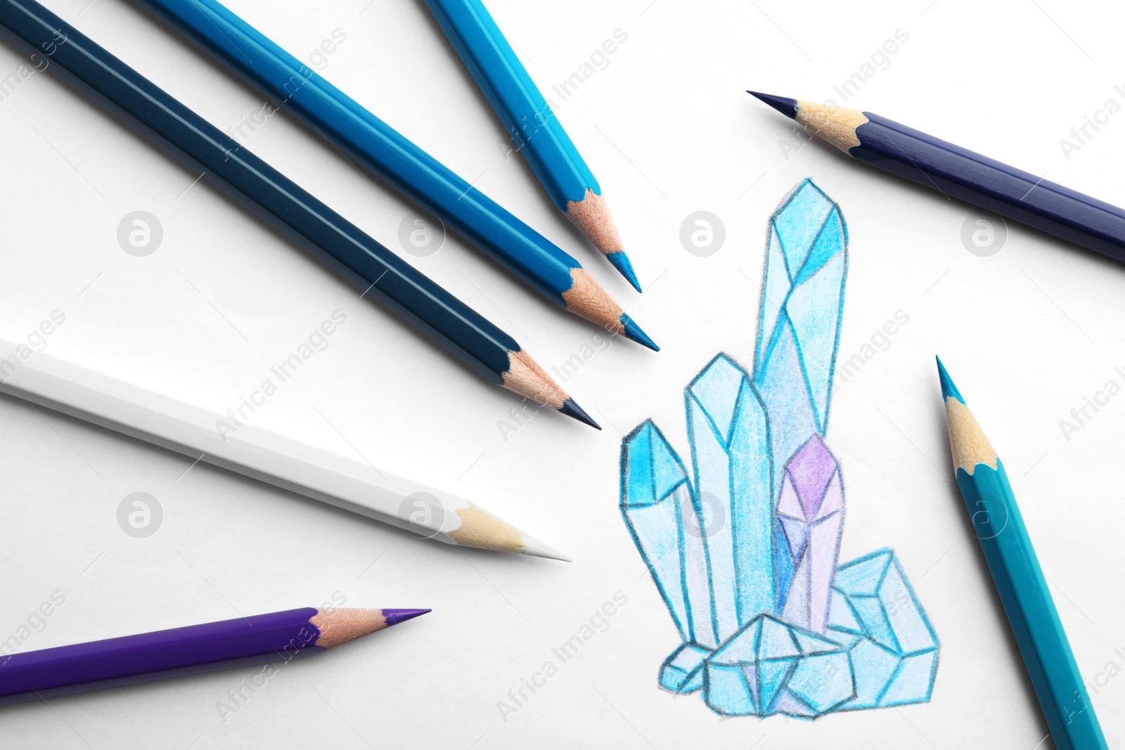 Photo of Drawing of crystals and colorful pencils on white background, top view