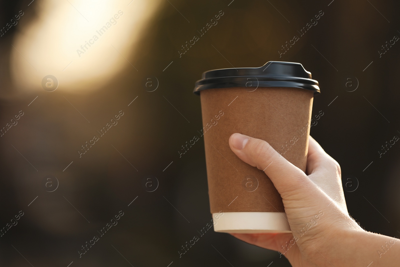 Photo of Woman with takeaway coffee cup outdoors, closeup. Space for text