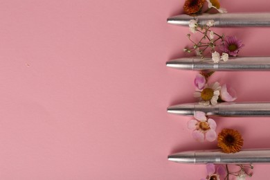 Bullets and beautiful flowers on pink background, flat lay. Space for text