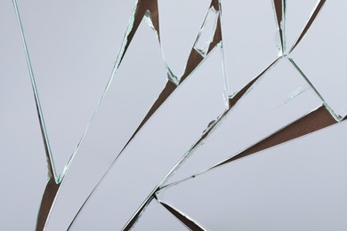 Photo of Shards of broken mirror on backing board, top view