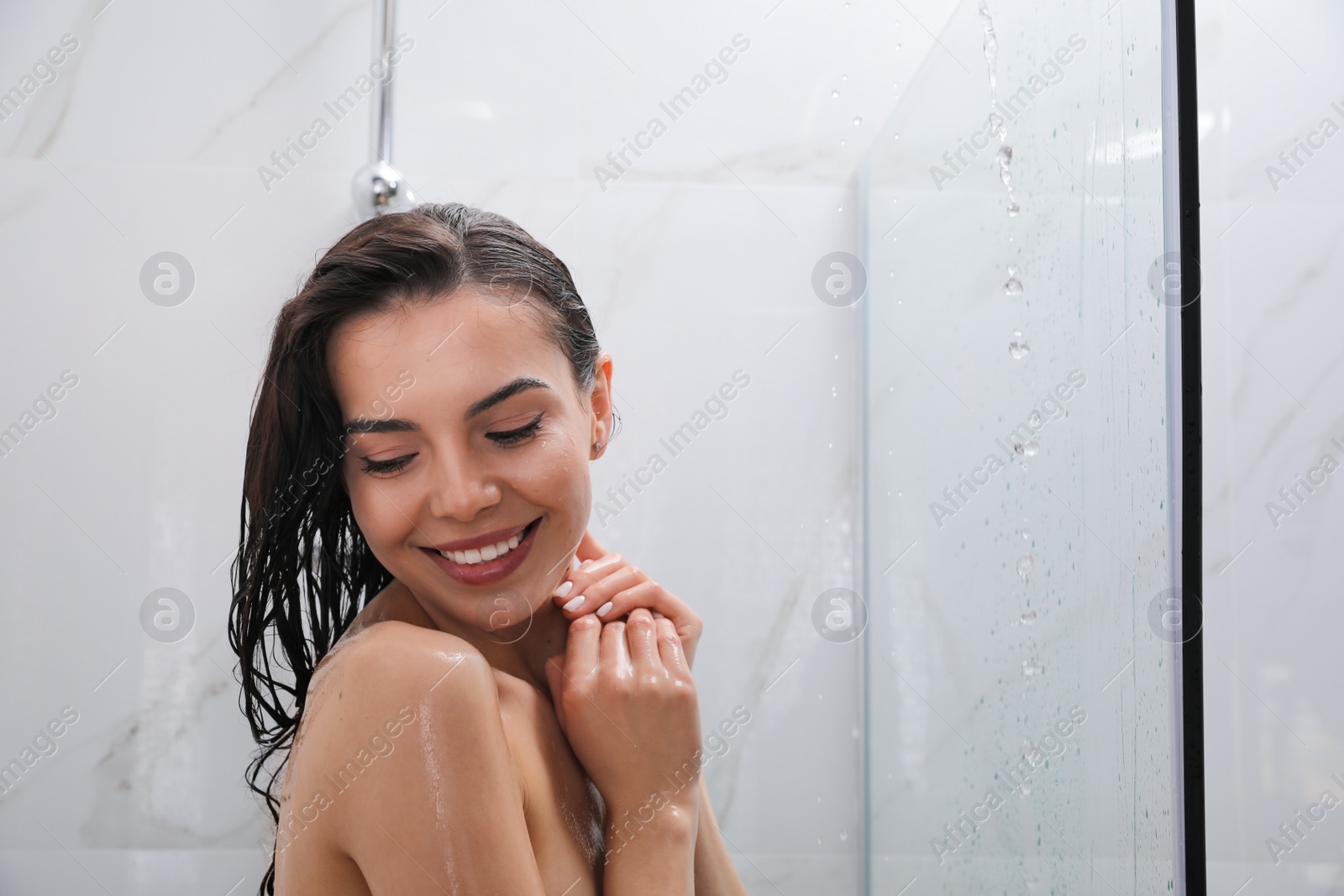 Photo of Beautiful young woman taking shower at home. Space for text