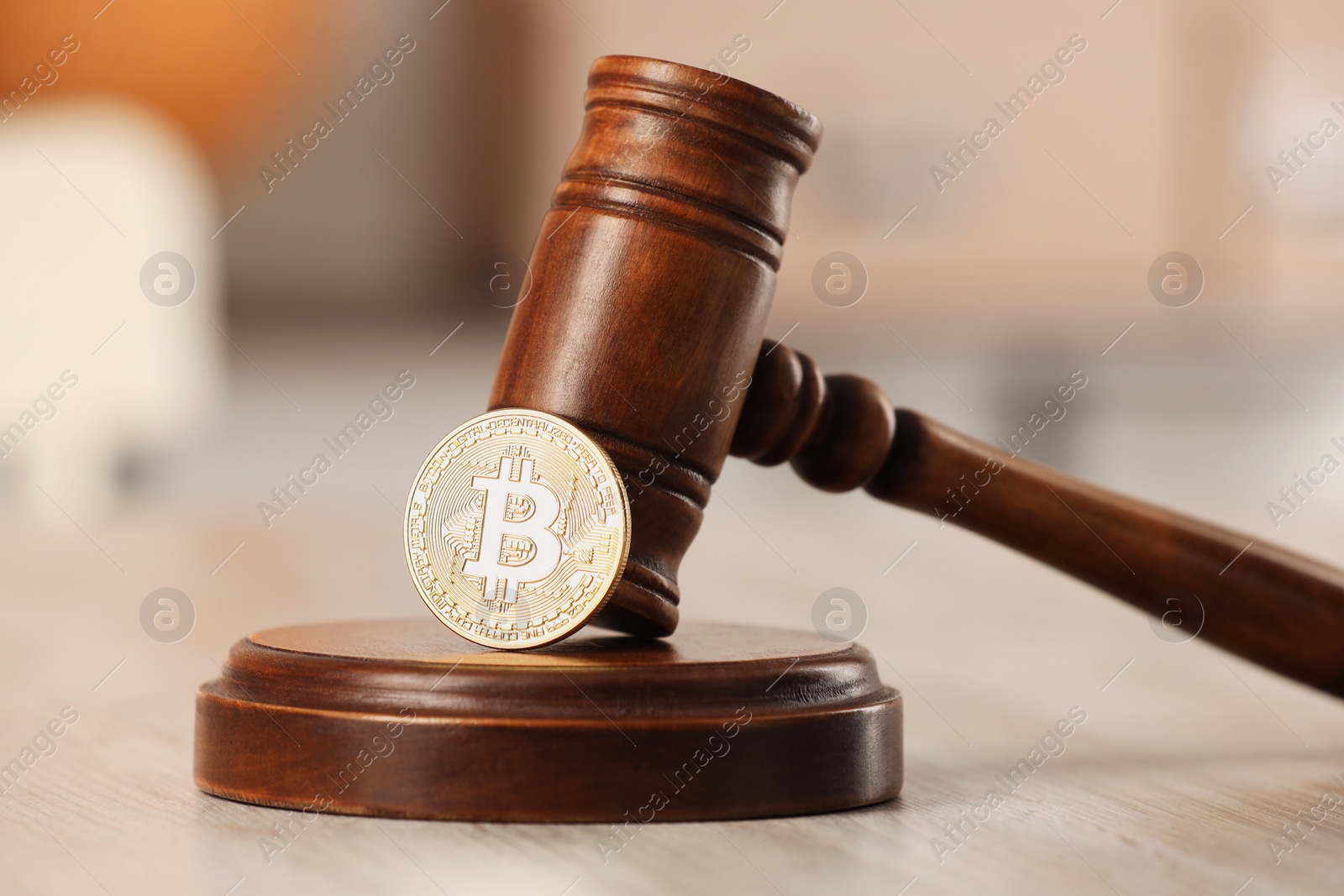 Photo of Law concept. Gavel and bitcoin on wooden table, closeup