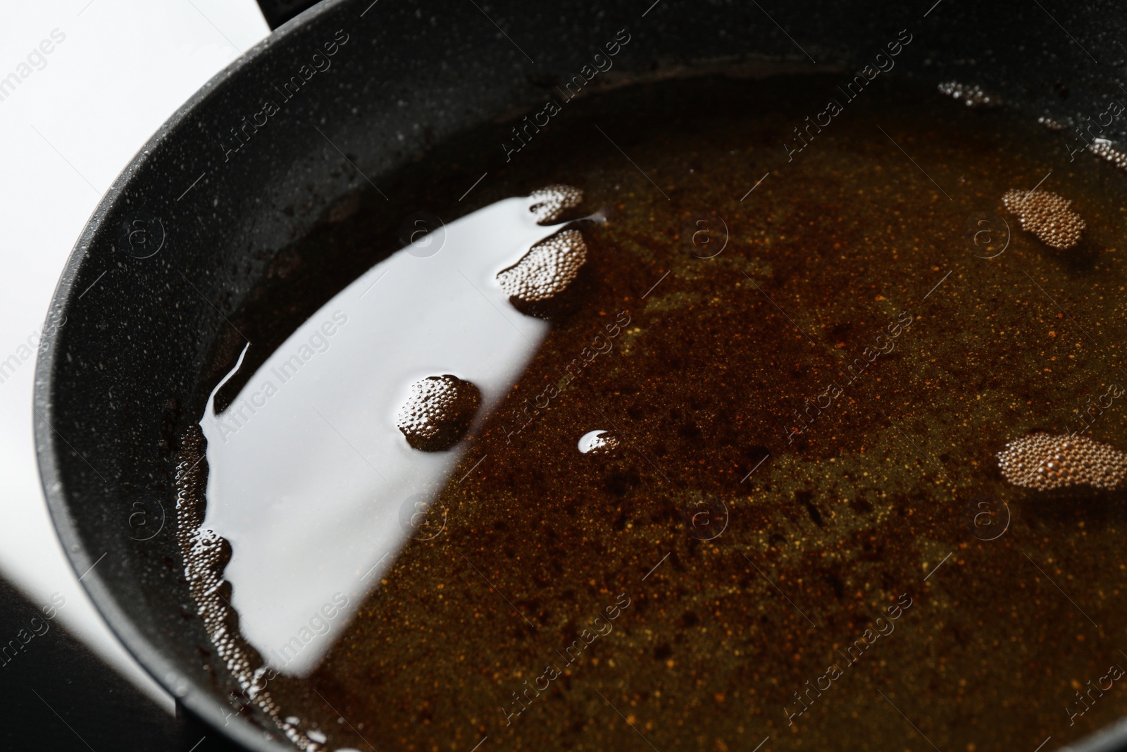 Photo of Used cooking oil in frying pan, closeup