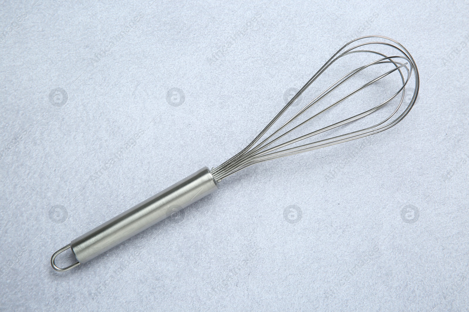 Photo of Metal whisk on gray table, top view