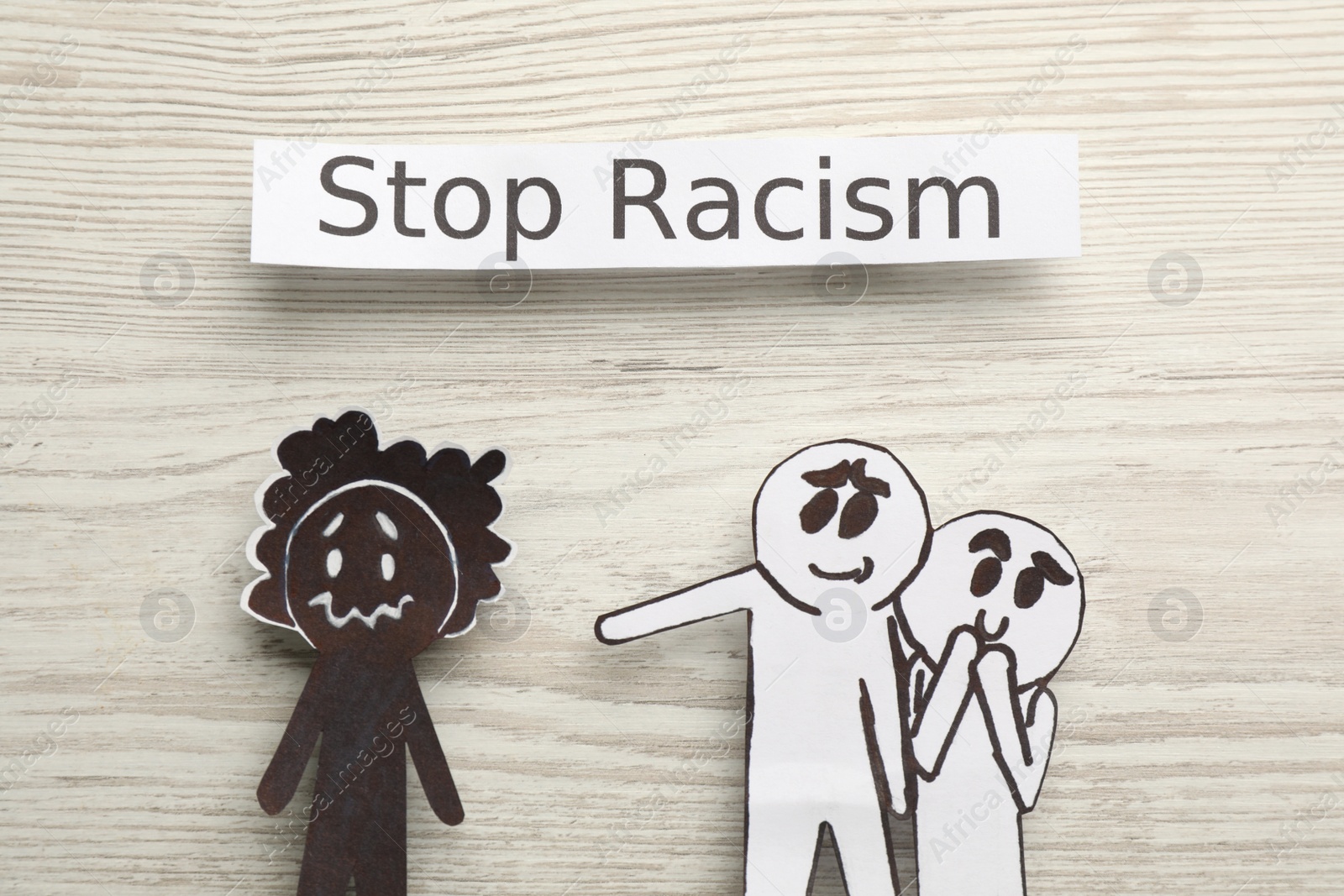 Photo of Flat lay composition with phrase Stop Racism and paper figures on white wooden table