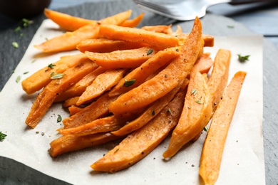 Photo of Tasty sweet potato fries on slate plate, closeup