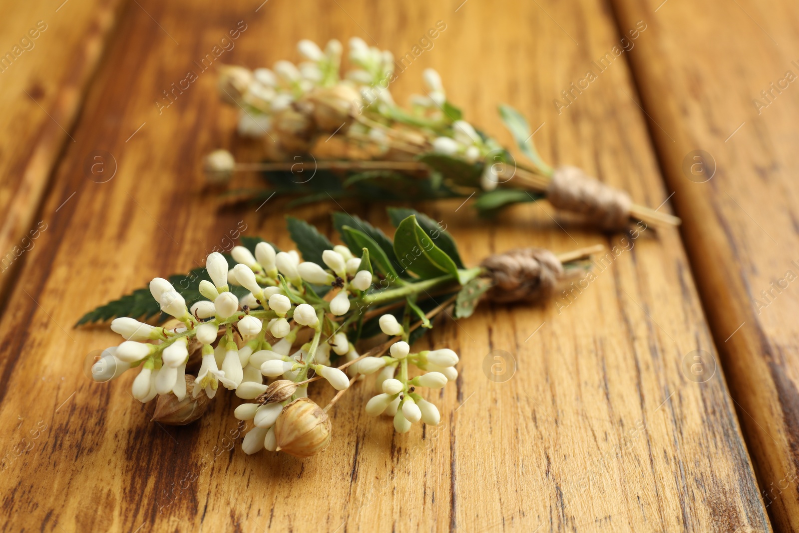 Photo of Small stylish boutonnieres on wooden table, closeup