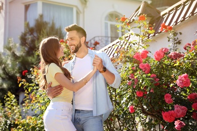 Lovely young couple dancing together outdoors on sunny day