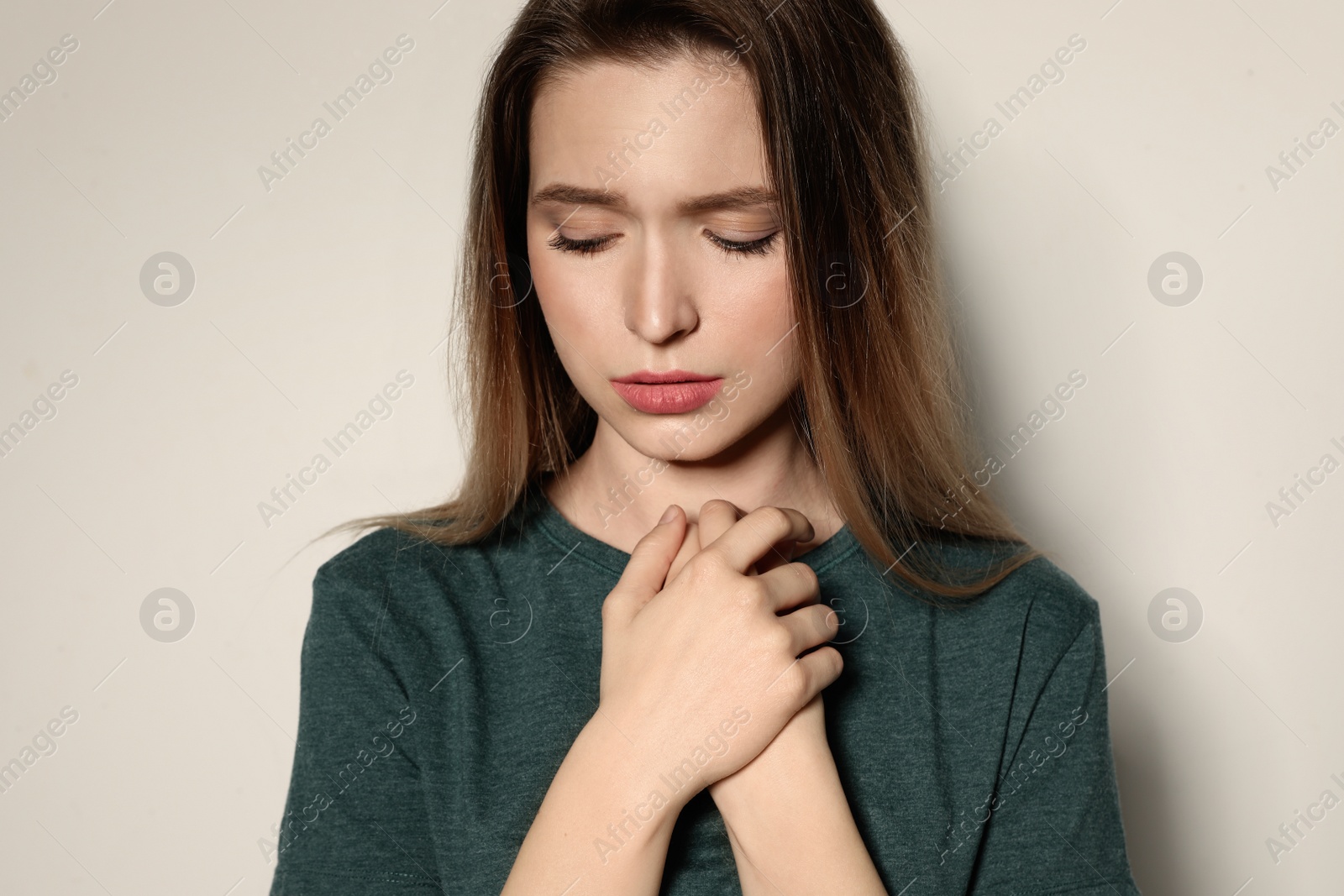 Photo of Portrait of upset young woman on light background