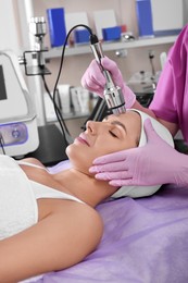 Photo of Woman undergoing cosmetic procedure in beauty salon. Microcurrent therapy