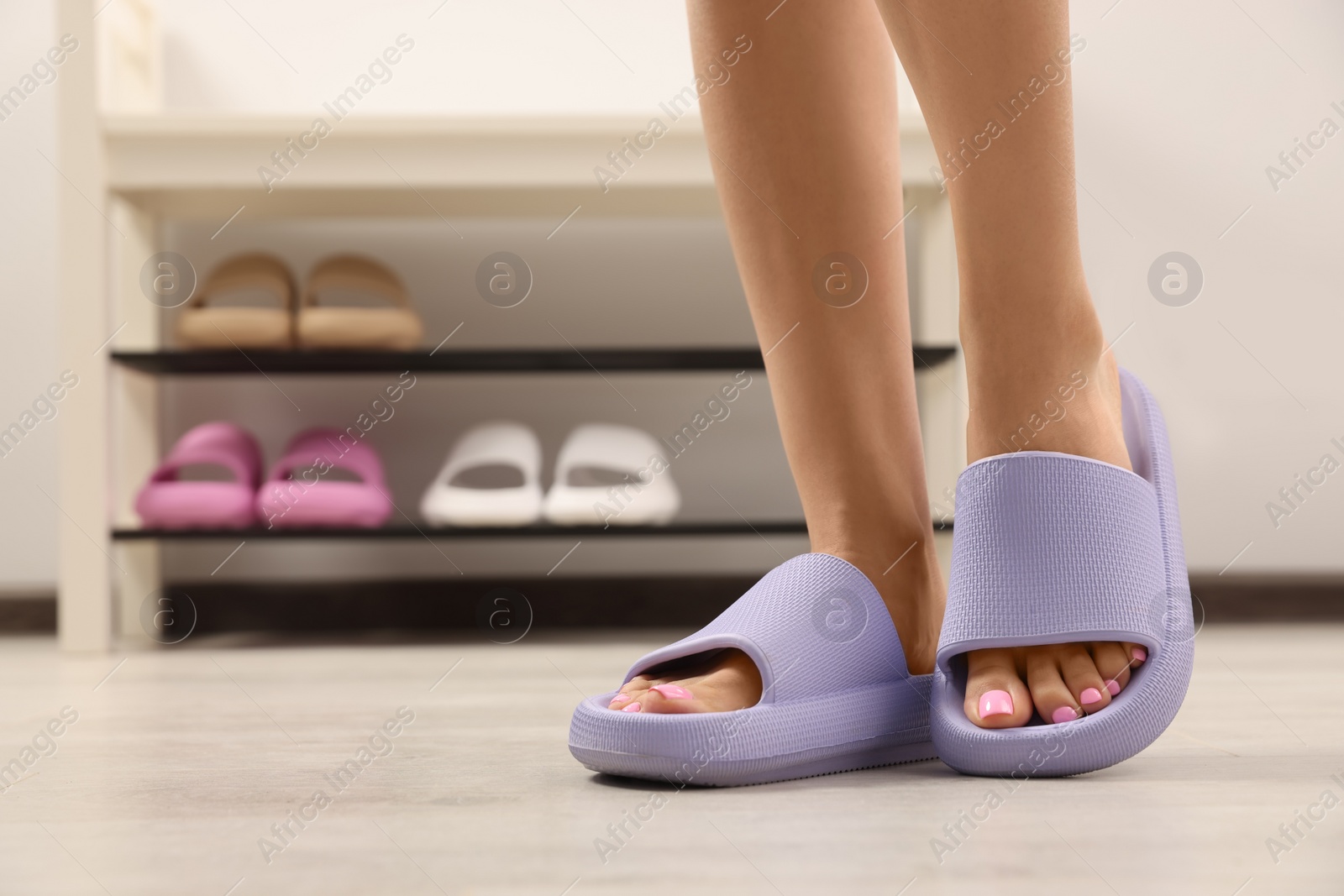 Photo of Woman wearing comfortable rubber slippers indoors, closeup. Space for text