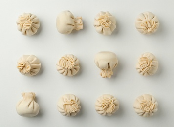 Composition with raw dumplings on white background, top view