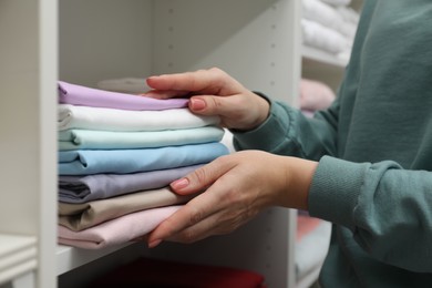 Photo of Customer choosing bed linens in shop, closeup
