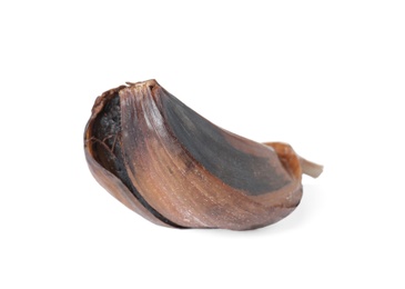 Unpeeled clove of aged black garlic on white background