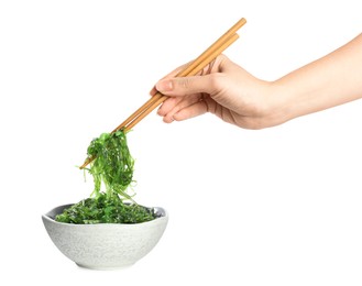 Photo of Woman holding chopsticks with Japanese seaweed salad over bowl isolated on white, closeup