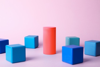 Photo of Different figure surrounded by cubes on color background