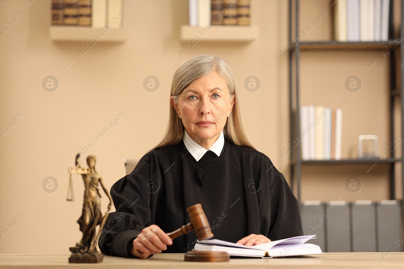 Photo of Judge striking mallet at wooden table indoors