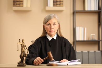 Photo of Judge striking mallet at wooden table indoors