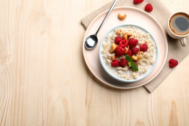 Flat lay composition with tasty oatmeal porridge on wooden table. Space for text