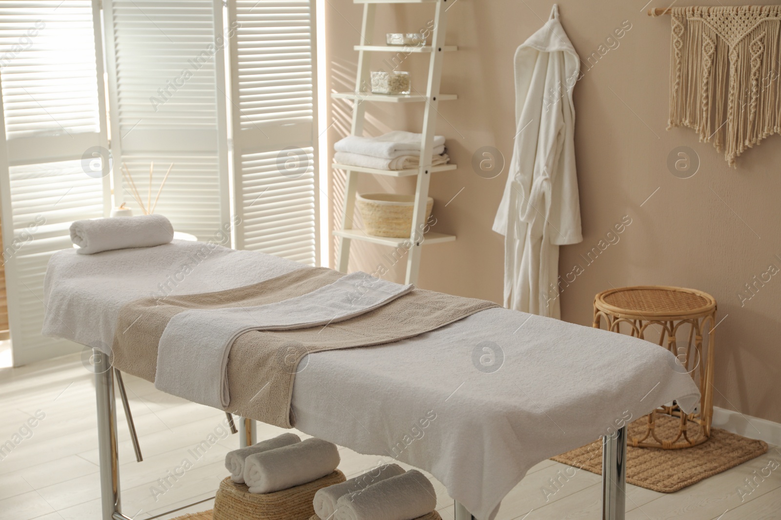 Photo of Stylish spa salon interior with massage table