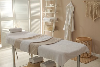 Stylish spa salon interior with massage table