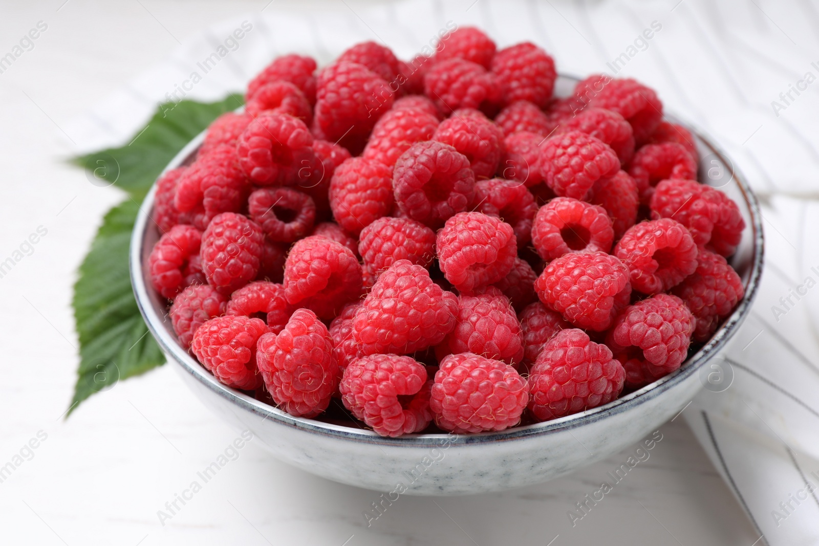 Photo of Delicious fresh ripe raspberries on white wooden table, closeup