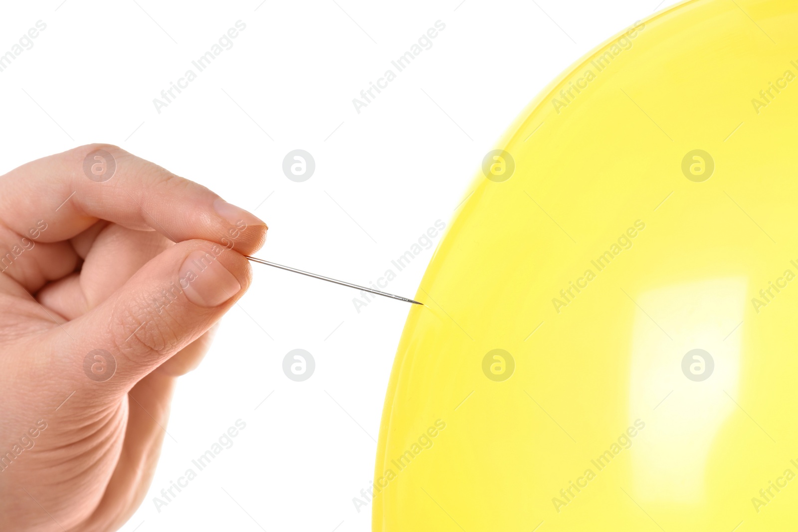 Photo of Woman piercing yellow balloon on white background, closeup