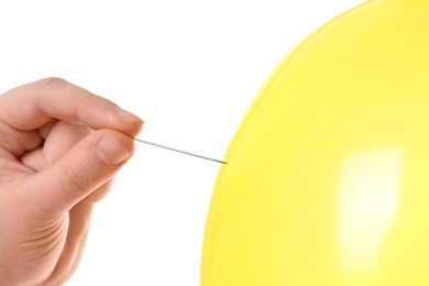 Woman piercing yellow balloon on white background, closeup