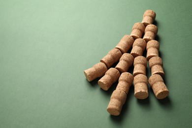 Christmas tree made of wine corks on green background. Space for text