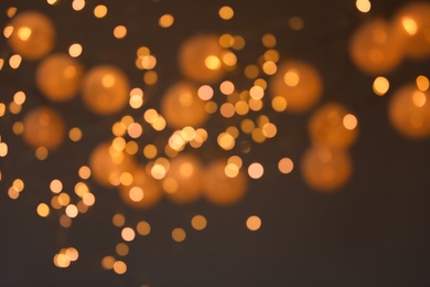 Photo of Blurred view of gold lights on dark background. Bokeh effect