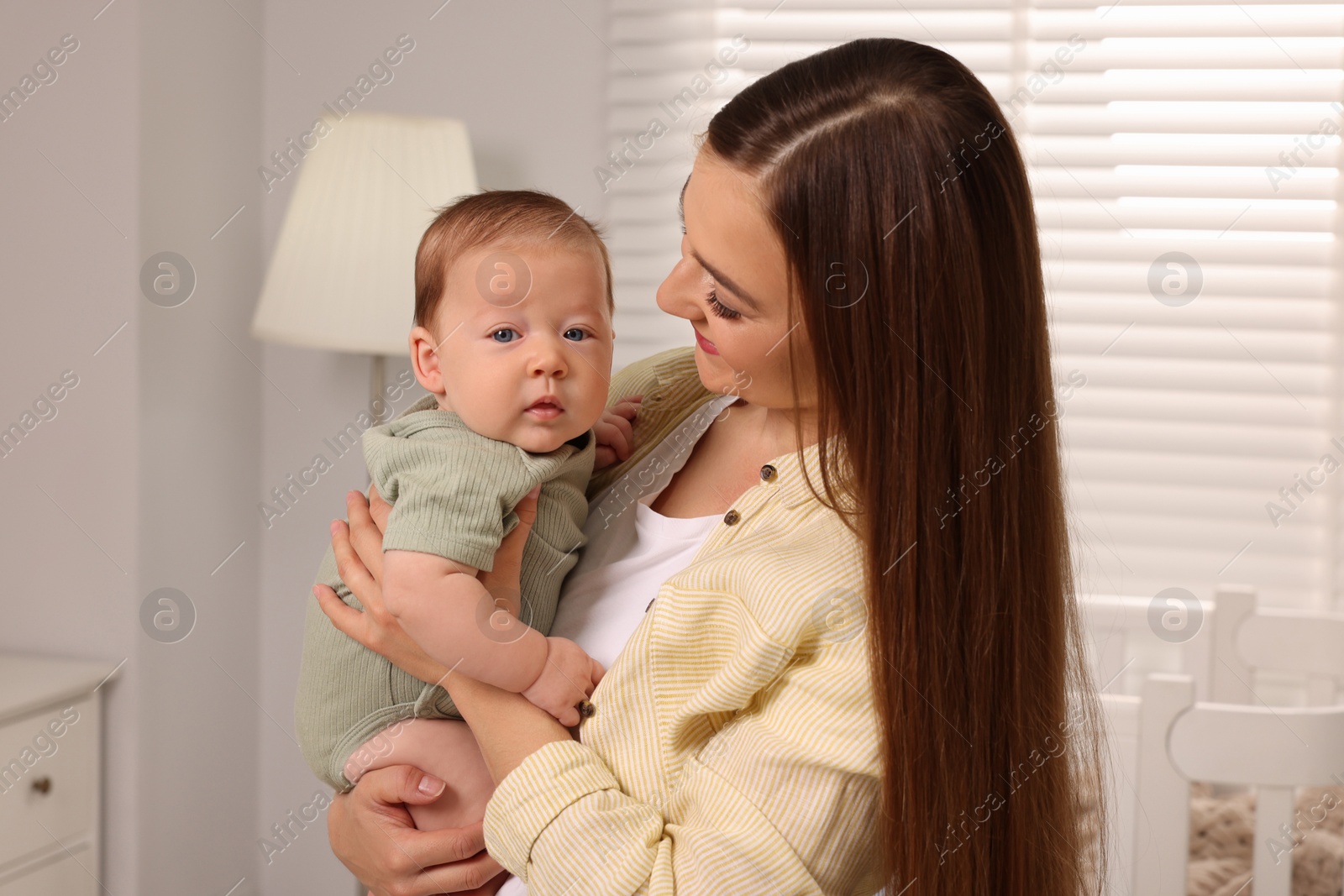 Photo of Mother holding her cute newborn baby at home