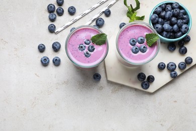 Photo of Freshly made blueberry smoothie on light grey table, flat lay. Space for text