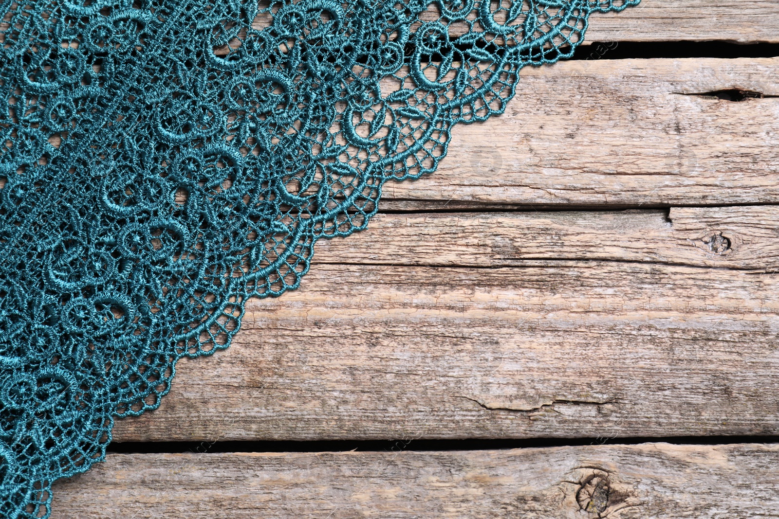 Photo of Beautiful lace on wooden table, top view. Space for text