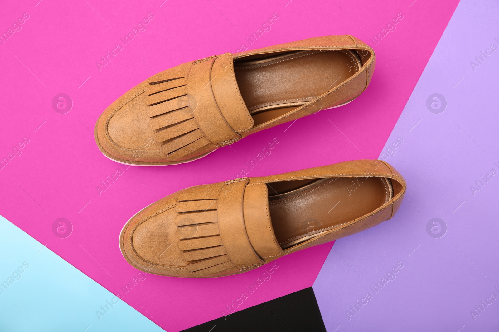 Photo of Pair of female shoes on color background