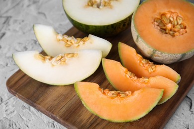 Tasty colorful ripe melons on white textured table