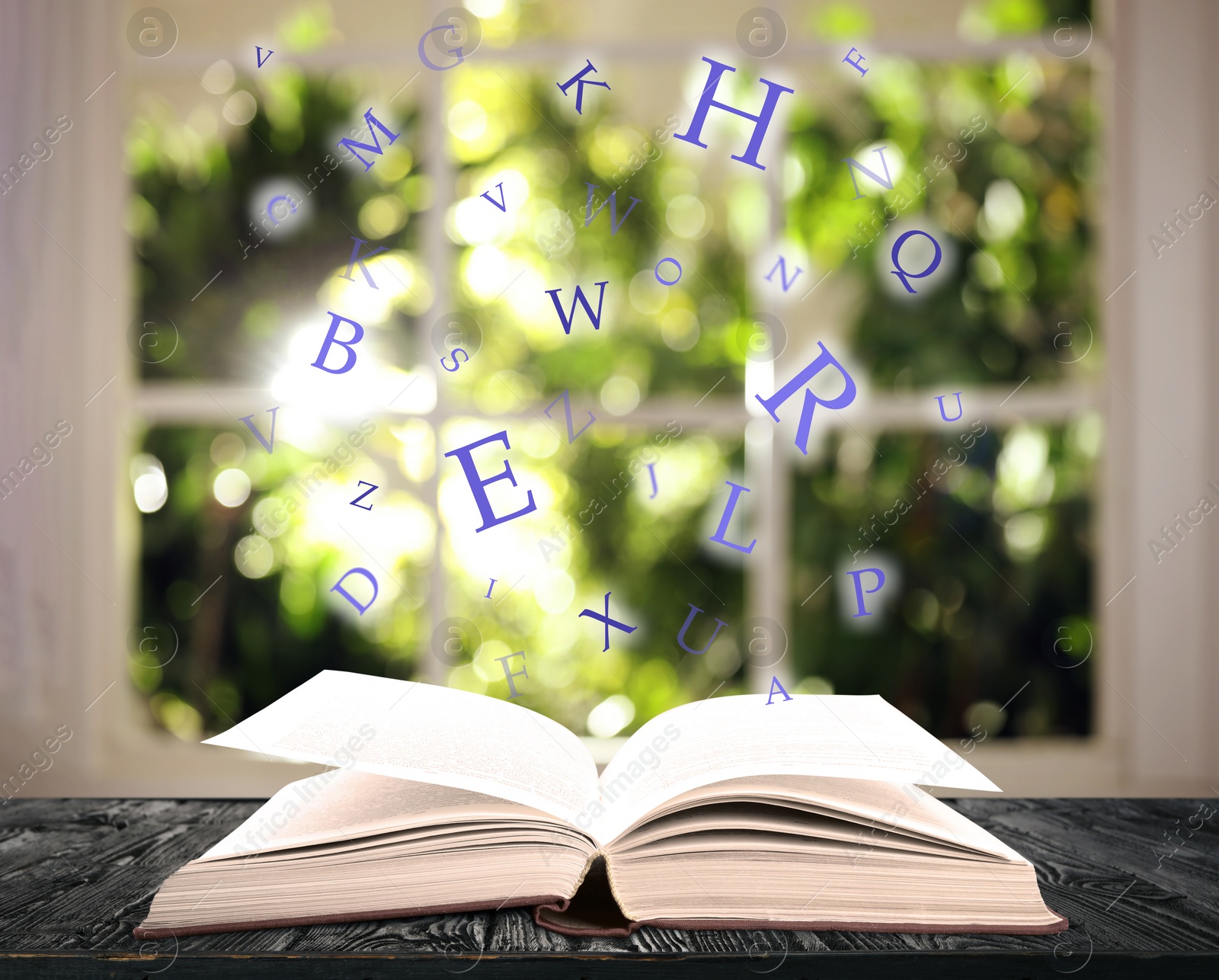 Image of Open book with letters flying out of it on wooden table against blurred background