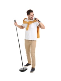 Young handsome man in casual clothes singing with microphone on white background