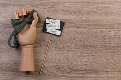 Hand holding bow tie on wooden background. Father's day celebration