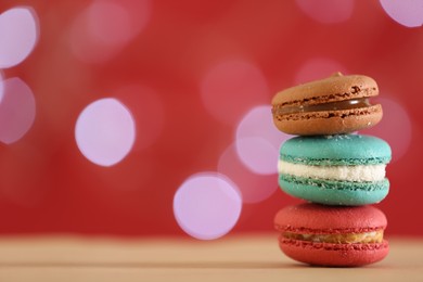 Photo of Delicious macarons on table against blurred background, closeup. Space for text