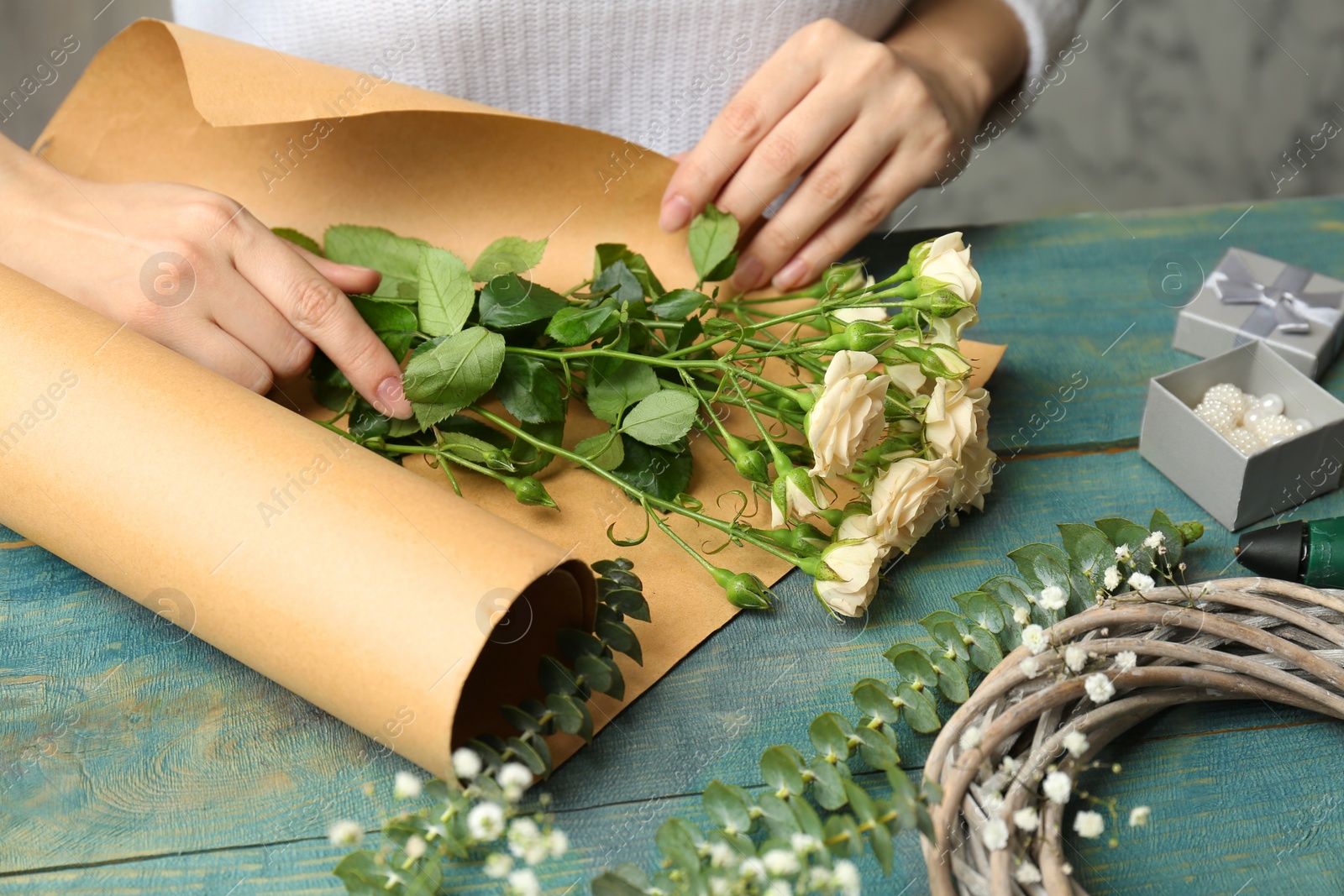 Photo of Female florist making beautiful bouquet at table