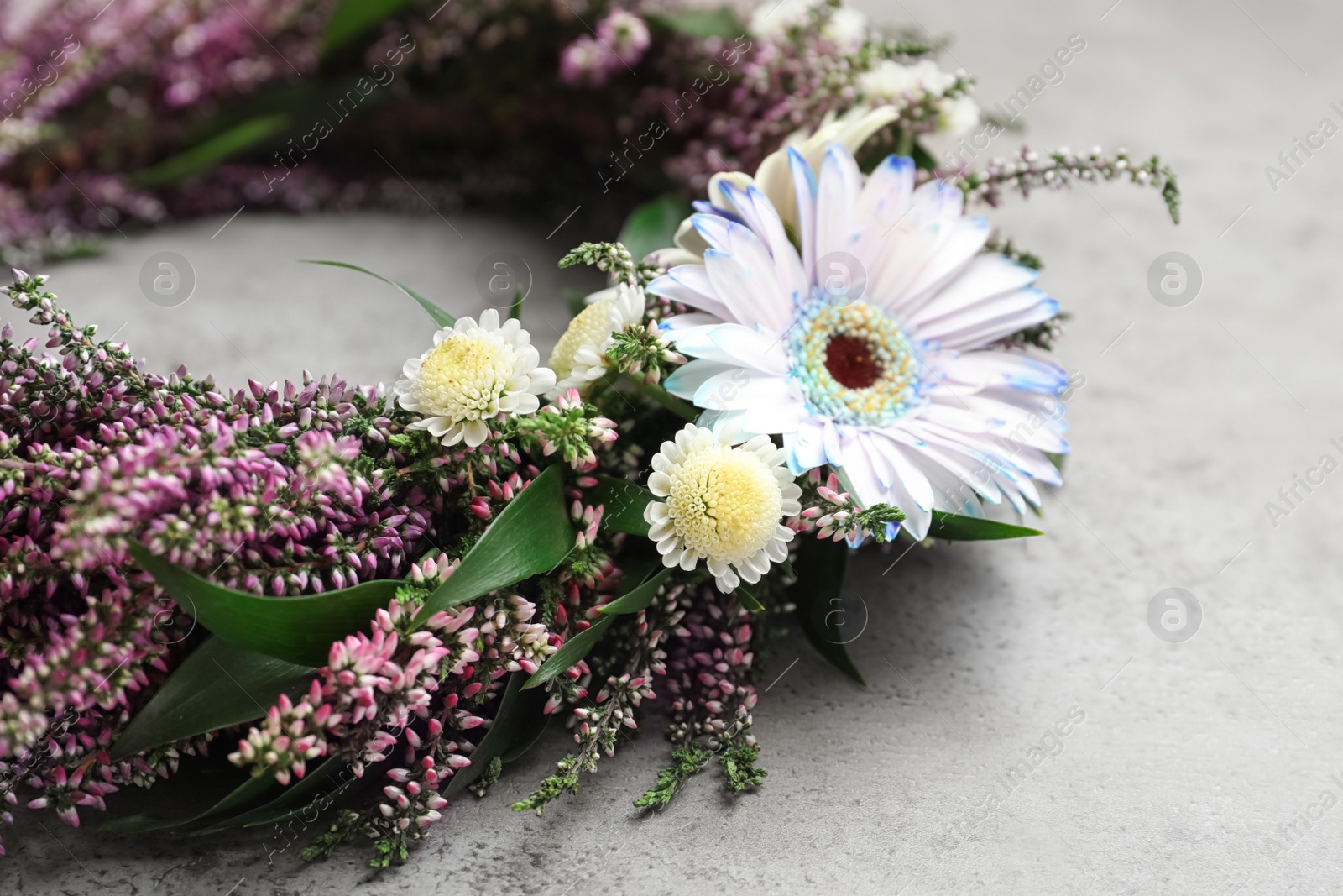 Photo of Beautiful autumnal wreath with heather flowers on light grey background, closeup