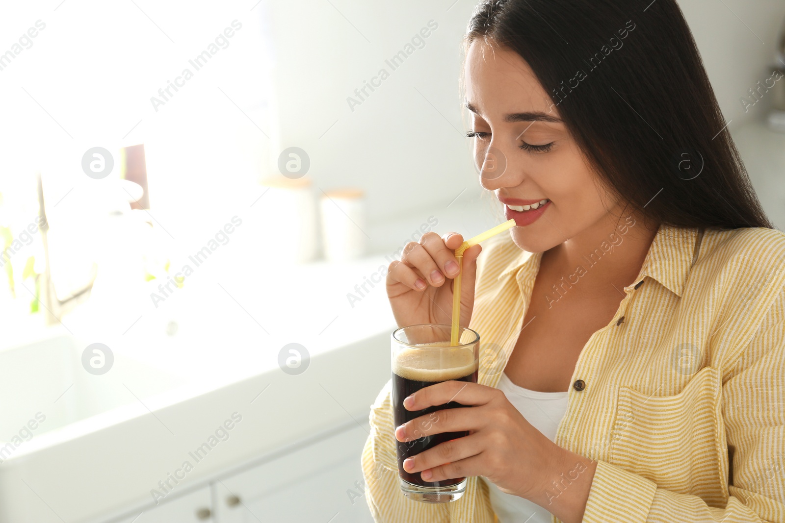 Photo of Beautiful woman with cold kvass indoors. Traditional Russian summer drink