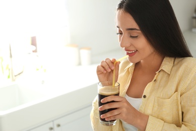 Photo of Beautiful woman with cold kvass indoors. Traditional Russian summer drink