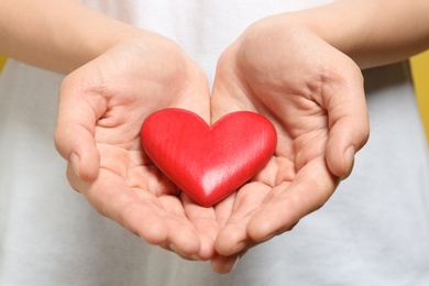 Photo of Woman holding red heart, closeup. Donation concept