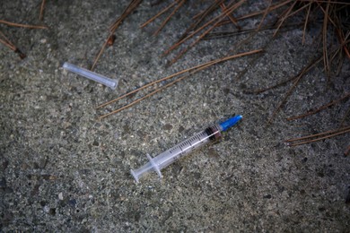 Photo of Disposable syringe with needle on stone surface