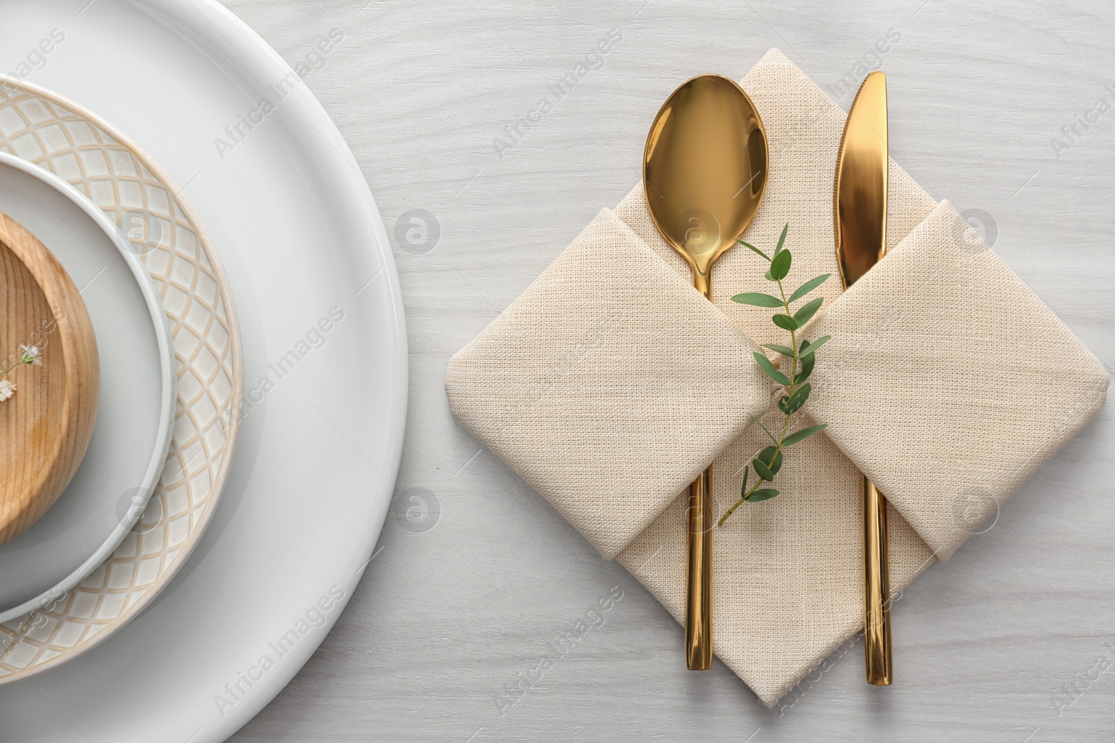 Photo of Elegant cutlery with green leaves on table, flat lay. Festive setting