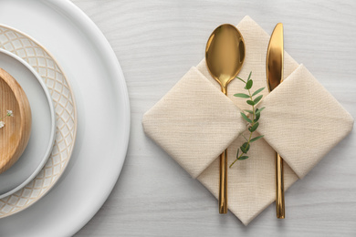 Photo of Elegant cutlery with green leaves on table, flat lay. Festive setting