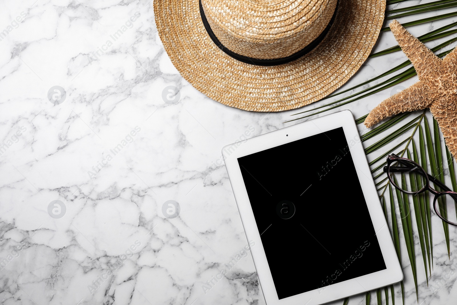 Photo of Flat lay composition with tablet and travel blogger's stuff on marble background, space for text