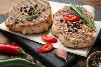 Photo of Delicious grilled pork steaks with spices on table, closeup